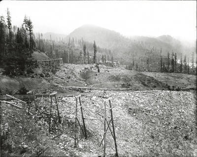 North side, Coeur d'Alene Mining District (Murray area). Rail supports are visible in the foreground of the photograph, while still standing tracks are visible on Barr's in the background.
