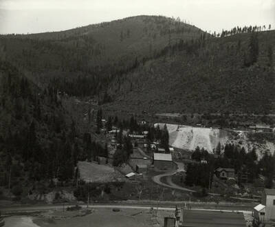 View of an unidentified area showing houses, a railroad bridge, outhouses, and a mill. The photo was taken for Mr. Strode, the proprietor of Mullan Water Company.