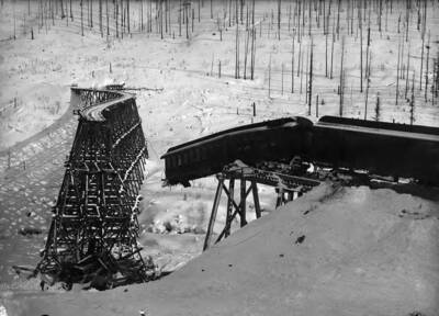 Image shows a train wreck on S Bridge, 1903, above Mullan, Idaho.