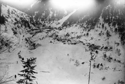 Image shows men assessing damage from a snowslide in Mace, Idaho, 1910.