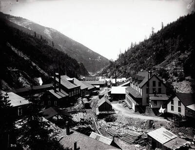 Showing man sitting outside of his log cabin