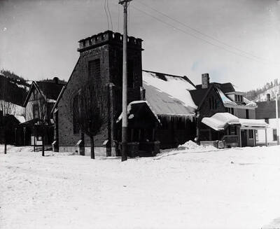 Snow scene of the exterior view of Holy Trinity Episcopal Church in Wallace, Idaho.