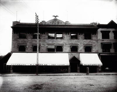 Exterior view of the Eagles block in May 1906, also shows Wallace Supply Co., W.J. Baker Co., and other offices in Wallace, Idaho.