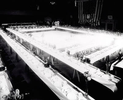 Interior view of the Eagles hall in Wallace, Idaho. Banquet tables are set and a group of wait staff is in the background.