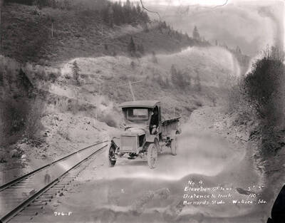 A meat truck on Mullan Road, one of the first major engineered highways in the Pacific Northwest that runs parallel to the current Interstate 90. Images shows a section of Mullan Road in Wallace, Idaho, 1924. H.E. Davis