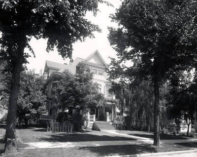 Image shows man sitting on the porch of C.W. Beale's house in Wallace, Idaho, 1925.