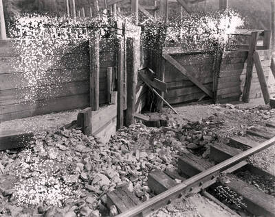 Image shows a portion of railroad track and rock around a broken flume on the Lee property in Wallace, Idaho, April 20, 1925.