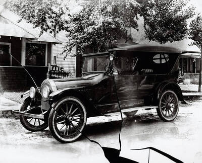 Kane's Auto building and in front of the building is an old automobile