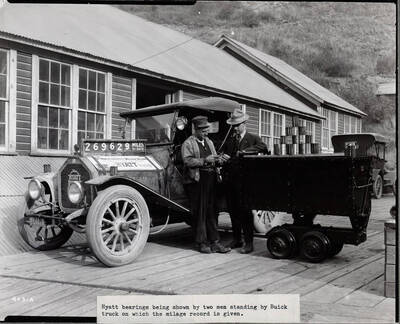 Two men standing outside Coeur d'Alene Hardware Co,