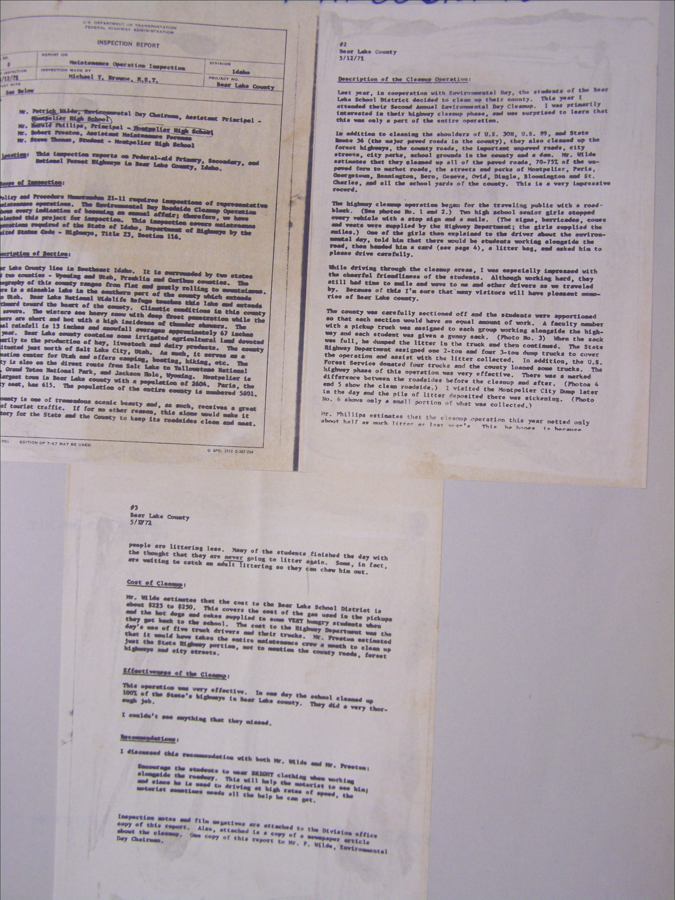 Three pages of typewritten text are arranged on a surface. The text includes titles such as "INSPECTION REPORT" and "Description of the Cleanup Operation." The document appears to detail a maintenance operation inspection in Bear Lake County, Idaho, dated 5/12/72. The text discusses a cleanup operation involving students and mentions costs, effectiveness, and observations regarding littering behavior.