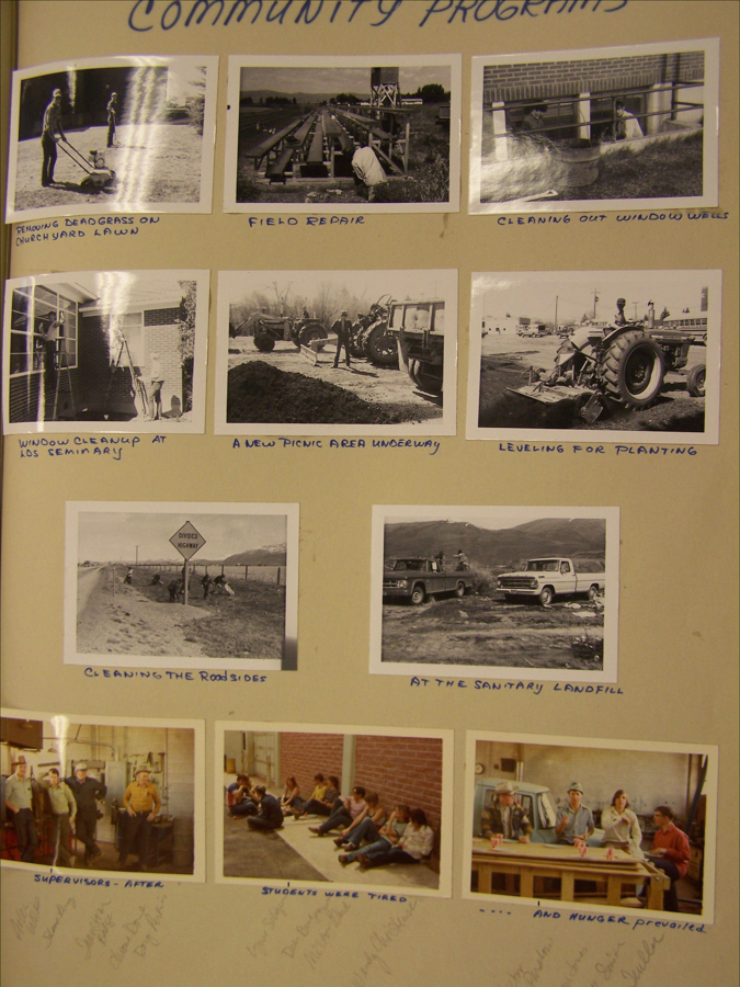 A collection of images titled "Community Programs." 

1. Two people mowing dead grass on a churchyard lawn.
2. A person working on field repair.
3. Two people cleaning out window wells.
4. A person cleaning a window at a seminary.
5. A group working on creating a new picnic area, involving tractors.
6. A tractor leveling a field for planting.
7. People cleaning the roadsides near a divided highway sign.
8. Two vehicles parked at a sanitary landfill with people nearby.
9. A group of supervisors standing together indoors after an event.
10. A group of students sitting on the ground, appearing tired.
11. Several people sitting at a table with drinks, with a note indicating hunger prevailed.