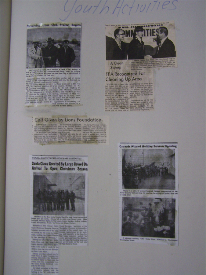 A scrapbook page labeled "Youth Activities" featuring five newspaper clippings. The articles cover various community events: one about a Lions Club project involving a calf, another recognizing FFA for cleaning efforts, and one about Santa Claus being greeted by a large crowd to open the Christmas season. Another clipping shows a holiday season opening with crowds, depicting a parade and children engaging with Santa.