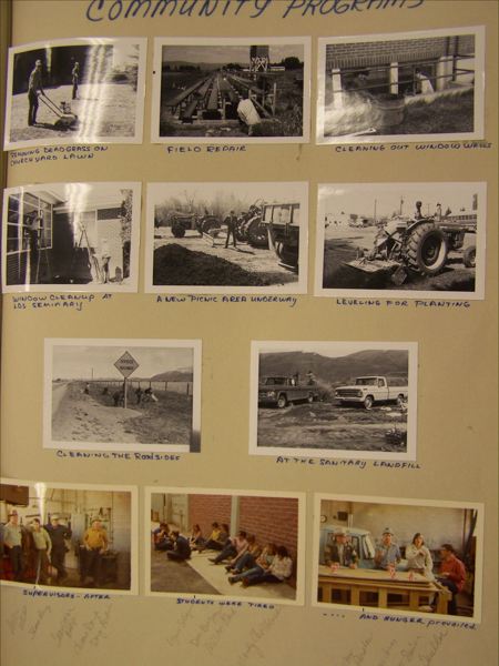 A collection of images titled "Community Programs." 

1. Two people mowing dead grass on a churchyard lawn.
2. A person working on field repair.
3. Two people cleaning out window wells.
4. A person cleaning a window at a seminary.
5. A group working on creating a new picnic area, involving tractors.
6. A tractor leveling a field for planting.
7. People cleaning the roadsides near a divided highway sign.
8. Two vehicles parked at a sanitary landfill with people nearby.
9. A group of supervisors standing together indoors after an event.
10. A group of students sitting on the ground, appearing tired.
11. Several people sitting at a table with drinks, with a note indicating hunger prevailed.