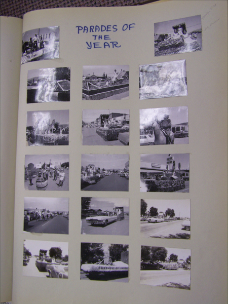A collection of sixteen small images arranged in a grid on a page. The top of the page features handwritten text stating "PARADES OF THE YEAR." The images depict various parade scenes with floats and people. Some floats have recognizable structures or themes, such as boats, cars, and figures. One image includes a building with a sign that reads "Food Town." Another float has the text "Chamber of Commerce" on it. There are handwritten annotations next to two of the images on the right side.