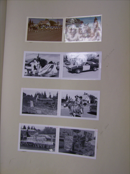 Seven images are arranged in two columns on a flat surface. The top row shows a marching band in a street and two riders on horses. The second row includes a parade float with a person standing on it and a car with people beside it. The third row has an image of a parade float and two people riding a donkey. The bottom row features a decorated vehicle marked "Junior 73" and another parade float. Handwritten text on the right reads "Holly Anna" and "John Albis."