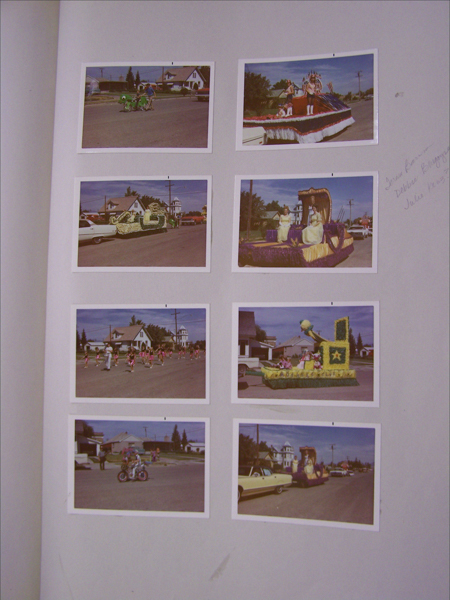 Eight images arranged on a page, each depicting a street parade. The upper left image shows people pushing a cart with green decorations. The upper right features a float with people standing on it, also decorated. Below on the left are people in red costumes walking. Next to it is another float with purple and yellow decorations, carrying two people. On the bottom left, a person rides a motorcycle. The bottom middle float has green decorations. The bottom right shows a yellow car and a float with ornate purple and yellow decorations. Houses and a building with a tower can be seen in the background. Handwritten text on the right reads: "Irene Brown, Debbie Reinger, Julie 1st 1973."