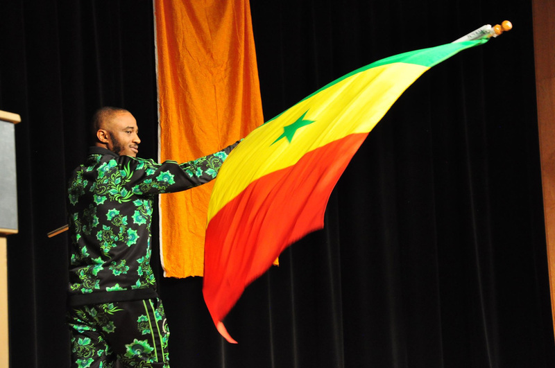Performer waves the Senegal flag on stage at the 2019 Africa Night.