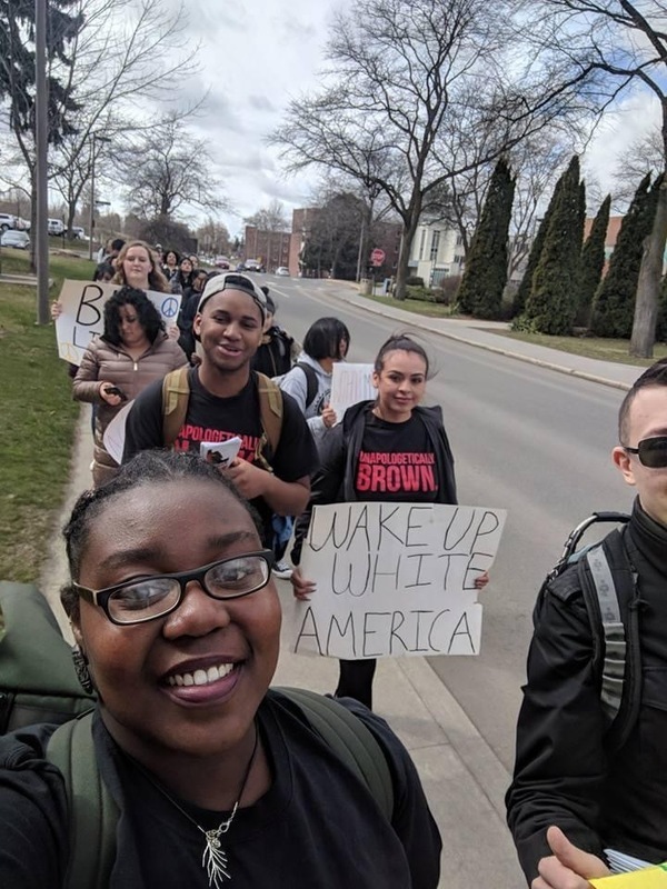 People with signs walking on campus during a Black Lives Matter Protest.