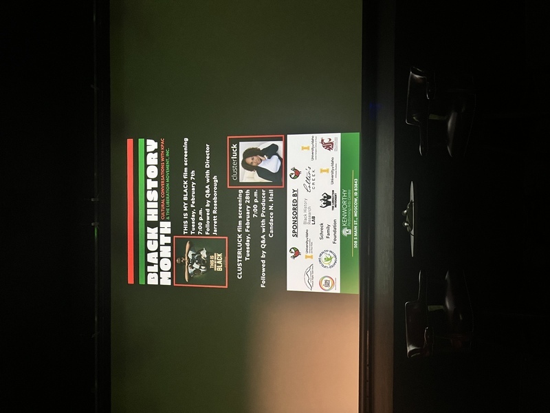 Screen displaying the poster for the Clusterluck screening inside the Kenworthy Theatre.