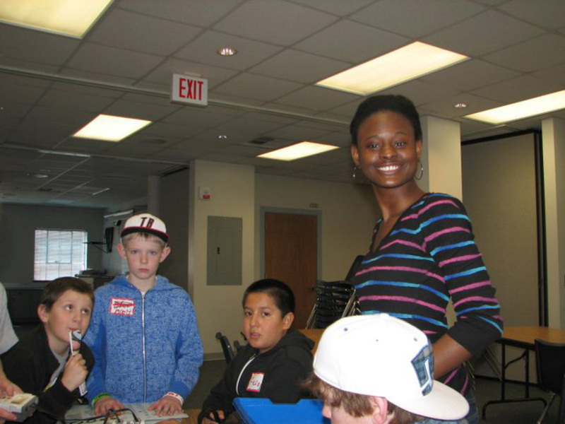 NSBE member helping students with an activity 
 at an engineering outreach event in 2011.