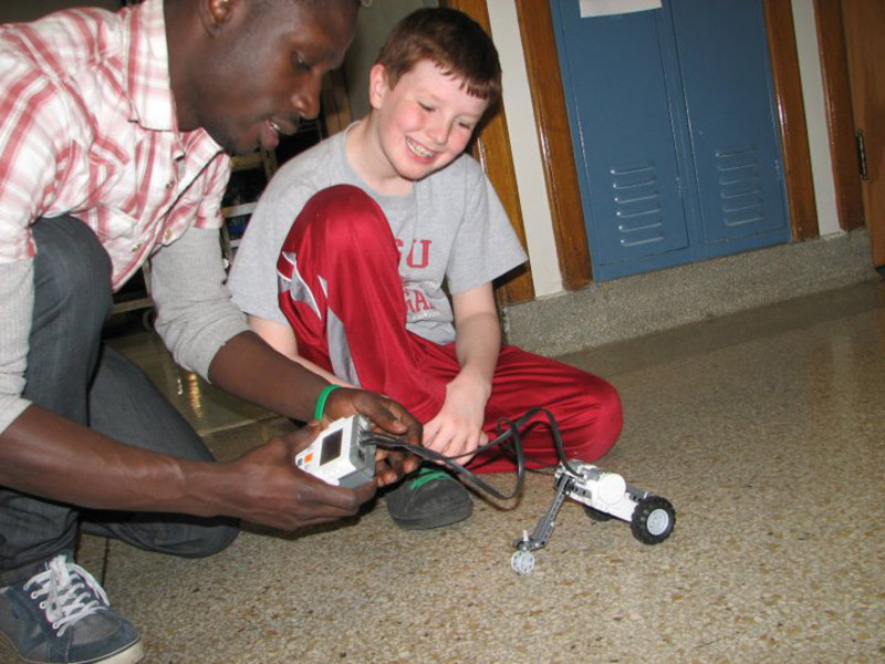Mouhamado Diop helps student with an activity 
 at an engineering outreach event in 2011.