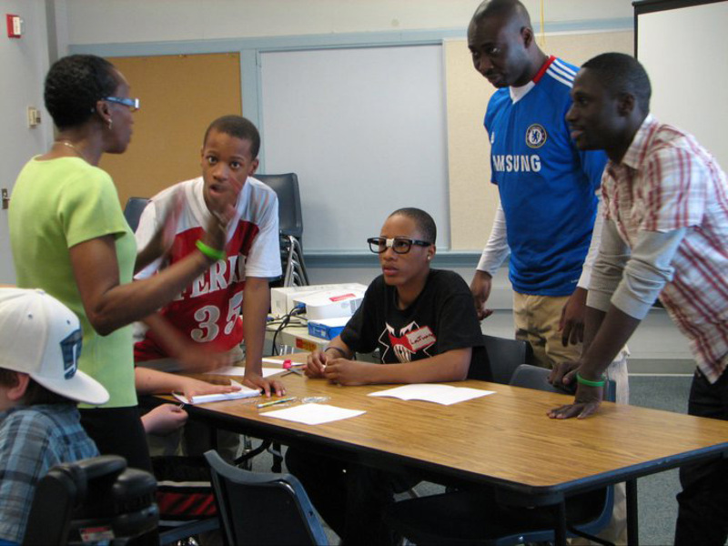 Mouhamado Diop and other NSBE member help students with an activity at an engineering outreach event in 2011.
