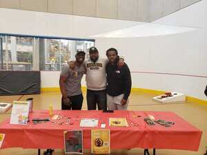 Mario Pile and students standing behind the BAACC table.