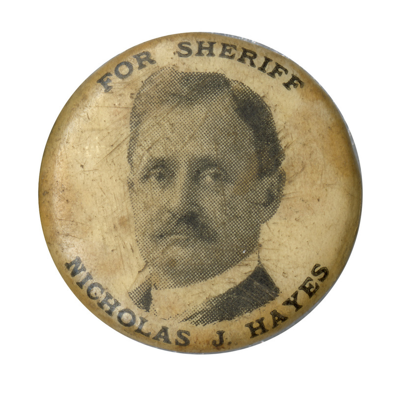 Round, white button with a portrait of Nicholas J. Hayes and the text: "For sheriff Nicholas J. Hayes".