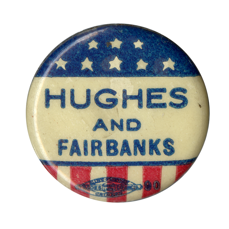 Round, white button with "Hughes and Fairbanks" in blue text. The top is adorned blue with white stars. The bottom is adorned with red and white stripes, resembling the U.S. flag.