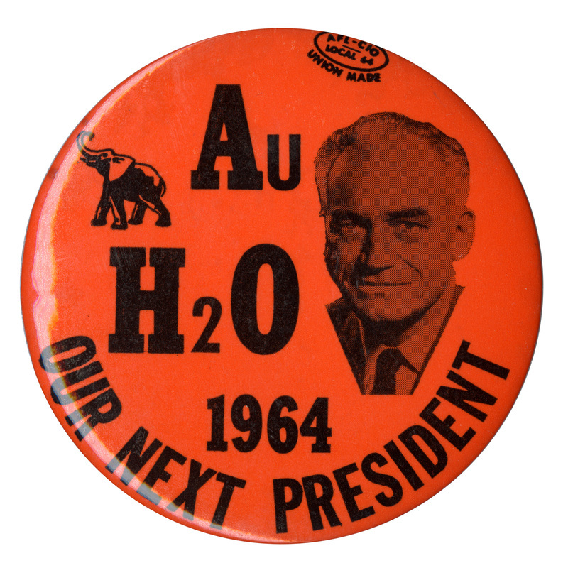Round, orange button with a portrait of Barry Goldwater and a black drawing of an elephant. Text on the button reads "Au H20 1964 Our Next President."