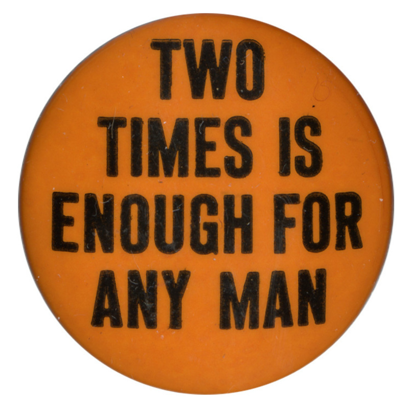Round, orange button with black text reading "Two times is enough for any man".