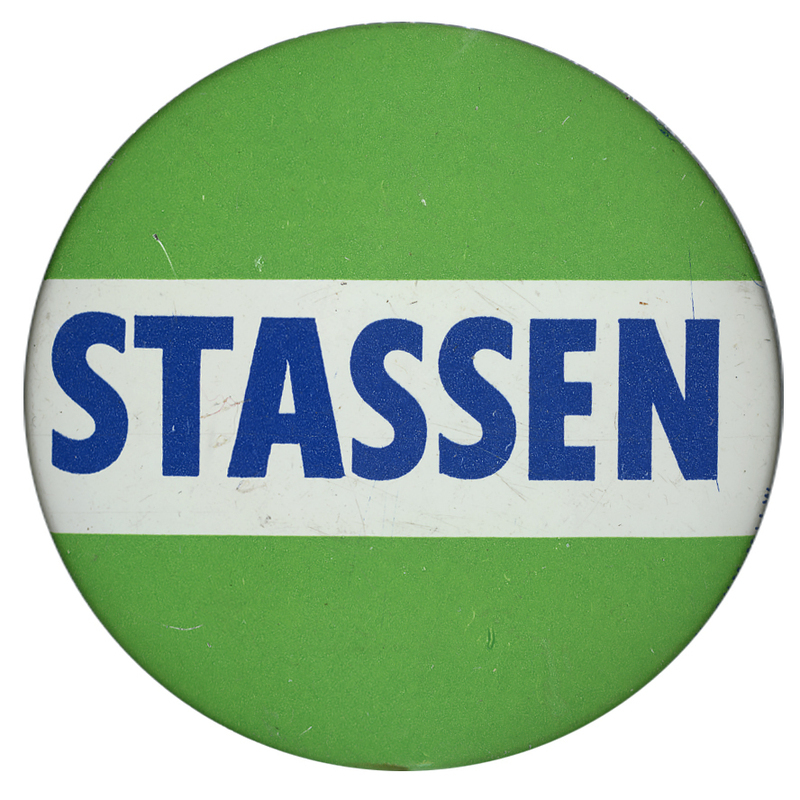 Round, light green button with a white, horizontal stripe and blue text reading "Stassen".