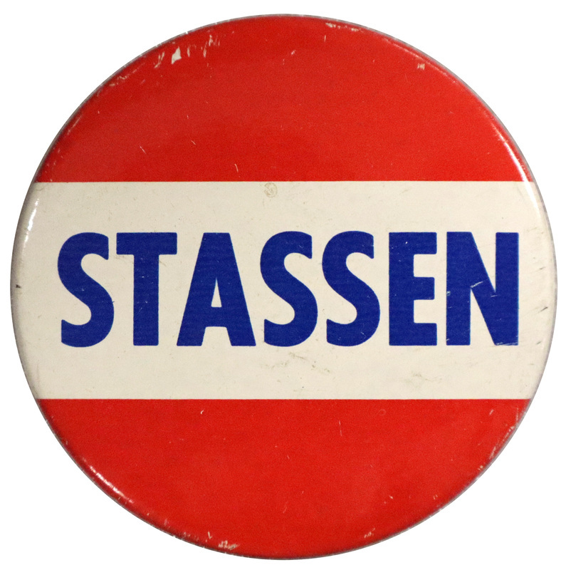 Round, red pin with a white horizontal stripe across the center. Across the white stripe is bold, blue text reading "Stassen". 