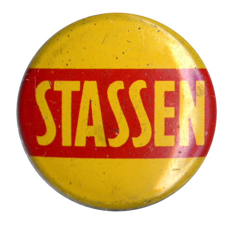 Round, yellow button with a red, horizontal stripe across the center. Bold, yellow text across the red stripe reads "Stassen". 