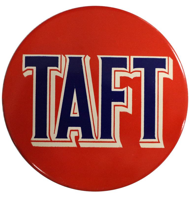 Round, red button with bold blue text that reads "Taft". The letters are bordered with white and red. 