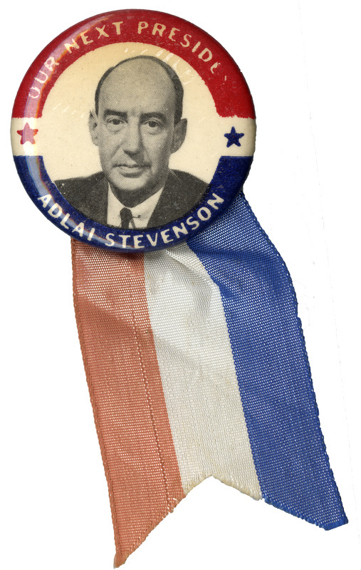 Round, white button with a red and blue border and a grayscale portrait of Adlai Stevenson. White text reading "Our Next President Adlai Stevenson" encircles the portrait. A red, white, and blue ribbon is attached at the bottom of the button. 