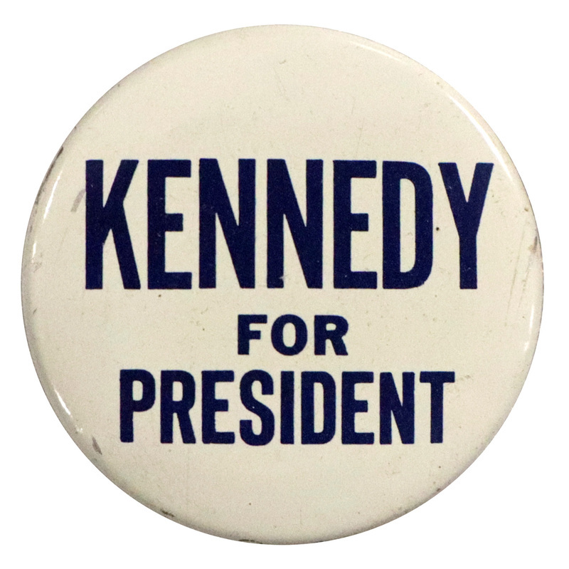 Round, white button with blue text reading "Kennedy for President". 