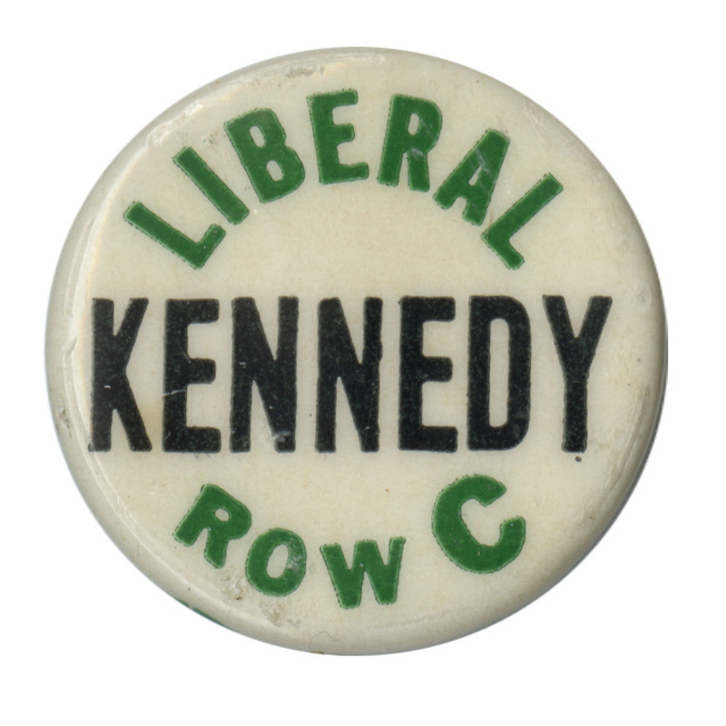 Round, white button with green and black text reading "Liberal Kennedy Row C". 