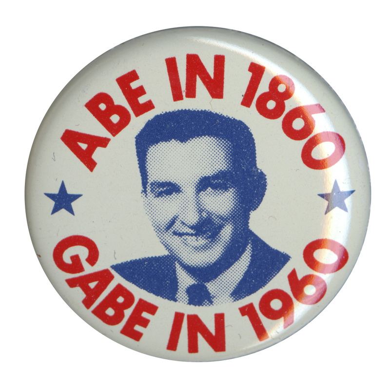 Round, white button with a grayscale portrait of Gabriel Green at the center. Red text reads "Abe in 1860 Gabe in 1960" and encircles the portrait. 