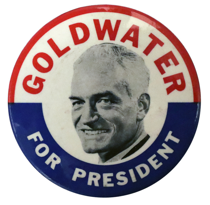 Round button with red and blue bands around the top and bottom and a black and white portrait of Barry Goldwater. The text reads "Goldwater for President."