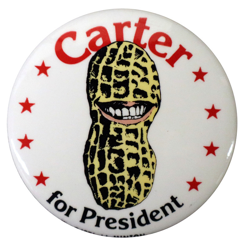 Round, white button with a color drawing of a peanut with a smiling mouth, surrounded by red stars. Red and black text reads "Carter for President"