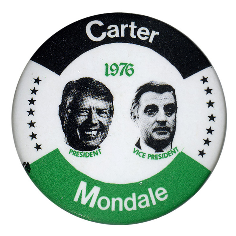 Round, white button with black and green bands and black stars along the edge. Black and white portraits of Jimmy Carter and Walter Mondale are in the center. Green and white text reads "Carter Mondale 1976 PRESIDENT VICE PRESIDENT"