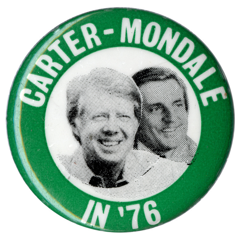 Round, green button with black and white photographs of Jimmy Carter and Walter Mondale in a white circle at the center. White text reads "CARTER-MONDALE IN '76"