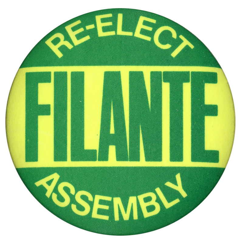 Round, green and yellow button with yellow and green text reading "RE-ELECT FILANTE ASSEMBLY"