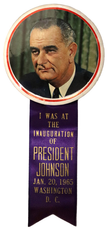 Round button with a color photograph of Lyndon B. Johnson surrounded by a red border. Attached to the button is a dark purple ribbon with gold text reading "I was at the Inauguration of President Johnson, Jan. 20, 1965, Washington, D.C."