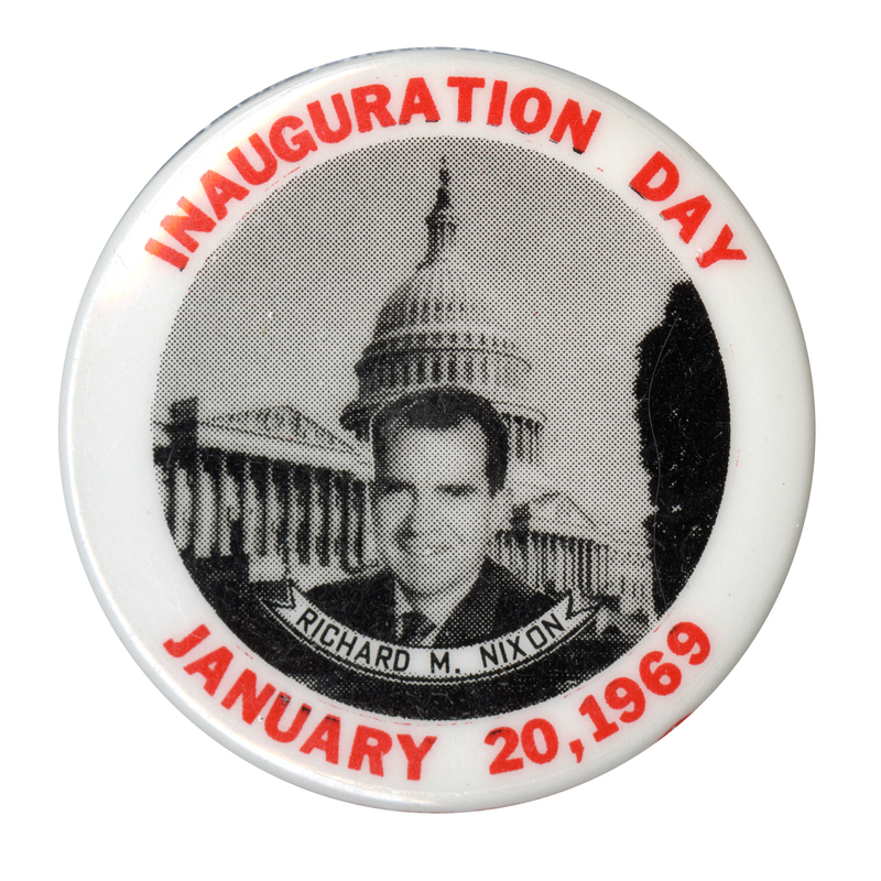 Round, white button with a black and white portrait of Richard Nixon in front of the US Capitol. Underneath Nixon's portrait is a ribbon with the text "Richard M. Nixon." Around the edge of the button is red text reading "Inauguration Day, January 20, 1969."