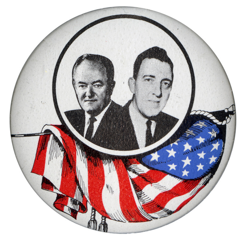 Round, white button with portraits of Hubert Humphrey and Edmund Muskie inside of a black circle above an illustration of the US flag in red, white, and blue. 