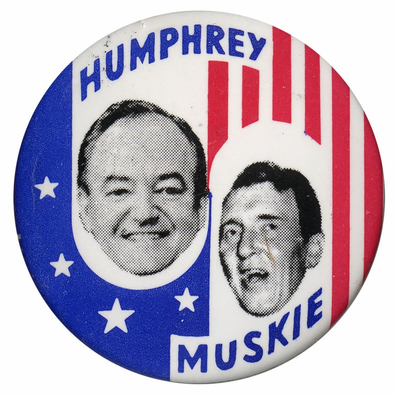 Round button with red, white, and blue flag design and portraits of Hubert Humphrey and Edmund Muskie. Text reads "Humphrey Muskie."