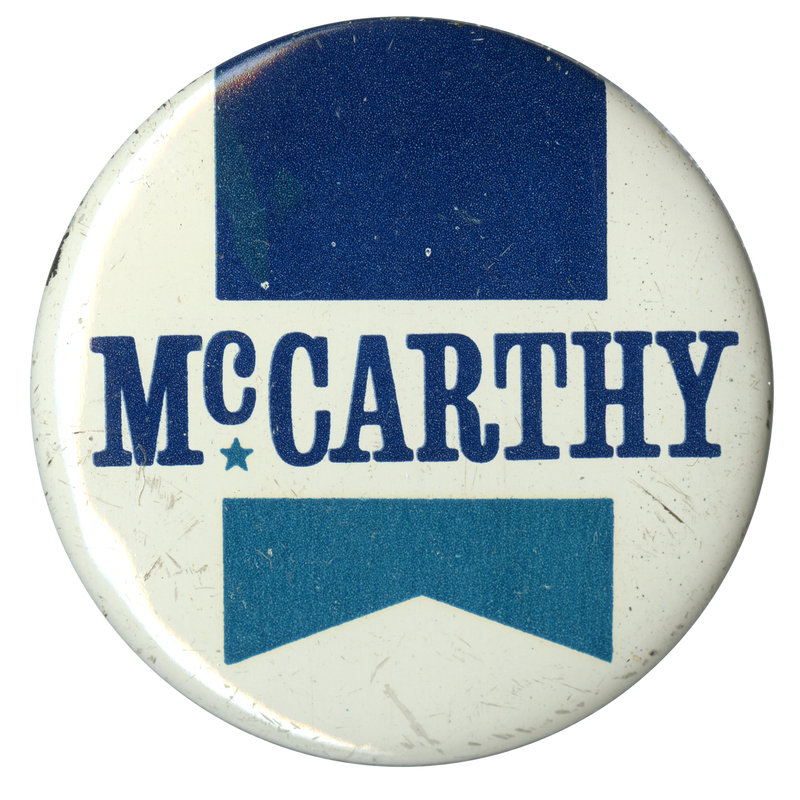Round, white button with a green and black ribbon illustration and black text reading "McCarthy."