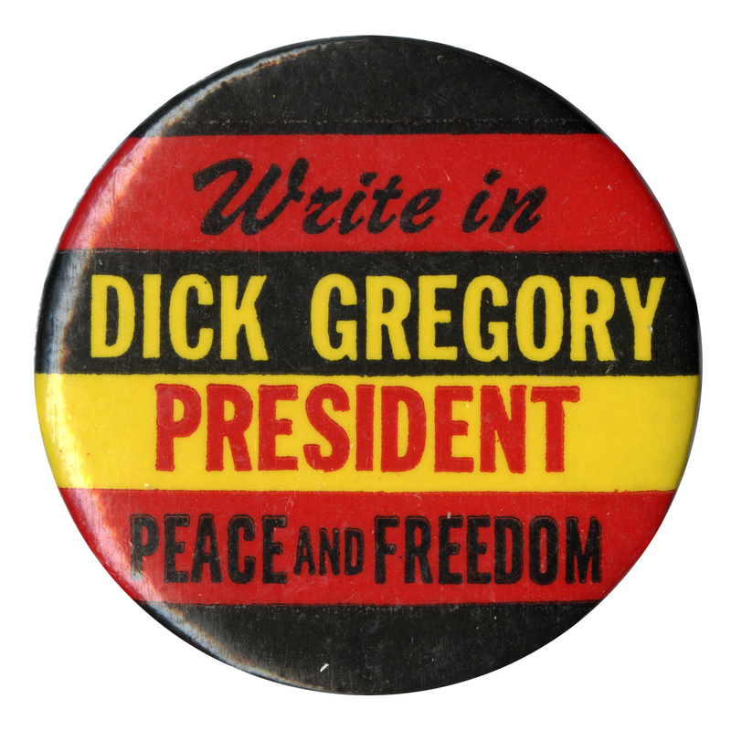 Round, red, black, and yellow button with text reading "Write in Dick Gregory President Peace and Freedom."
